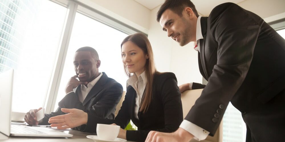 multiracial-business-partners-using-laptop-during-meeting-looki